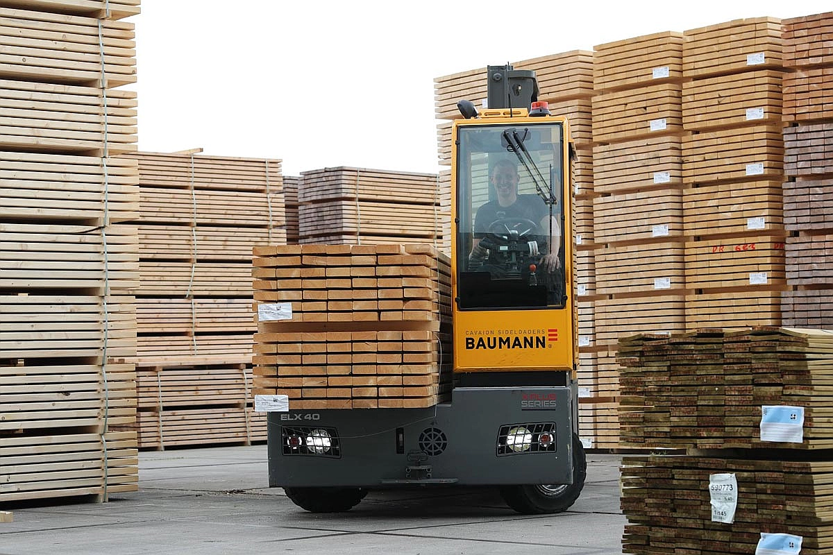 Baumann sideloader forklift transporting timber in lumber yard